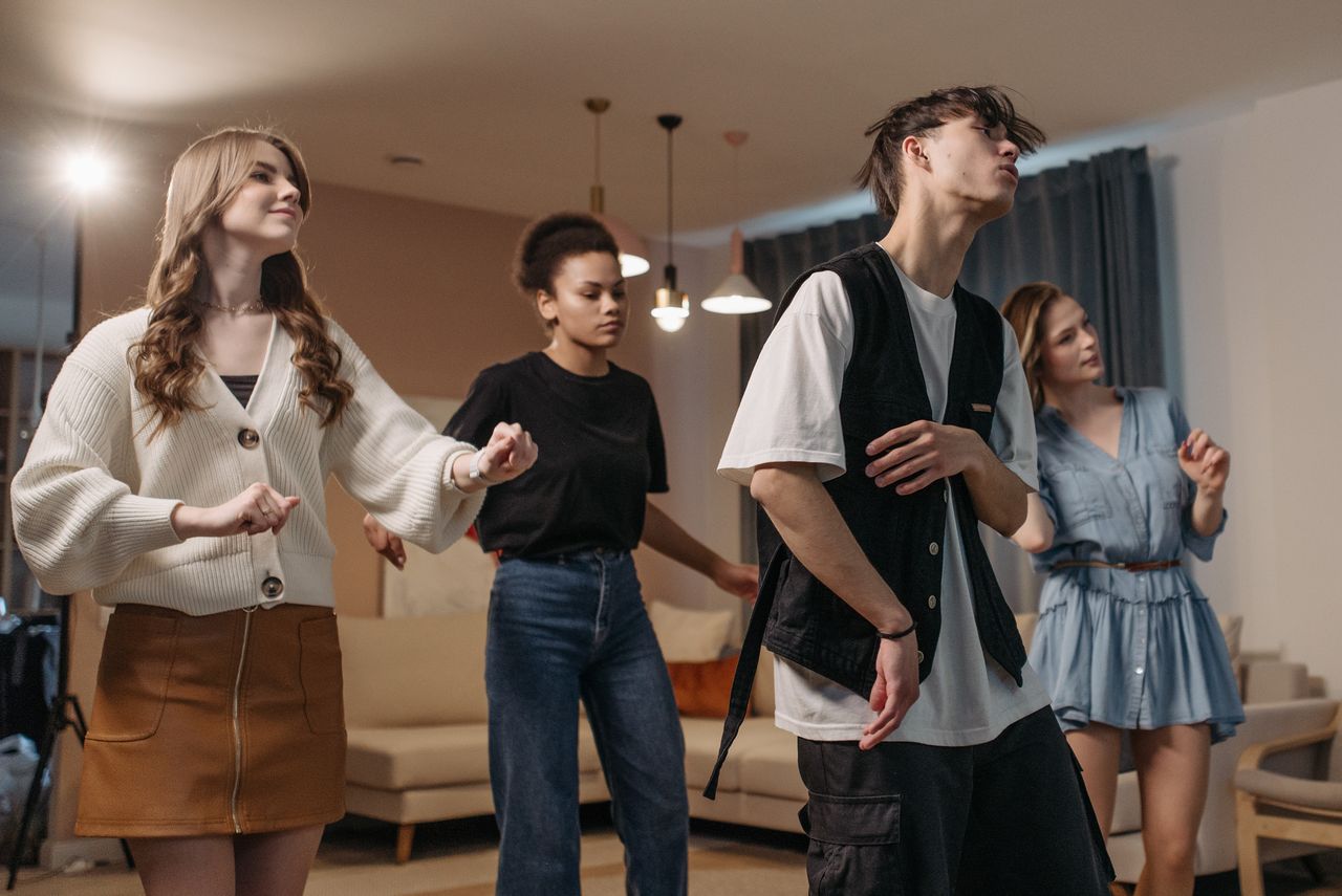 Services A group of young adults enjoying a dance party indoors, showcasing diversity and friendship.